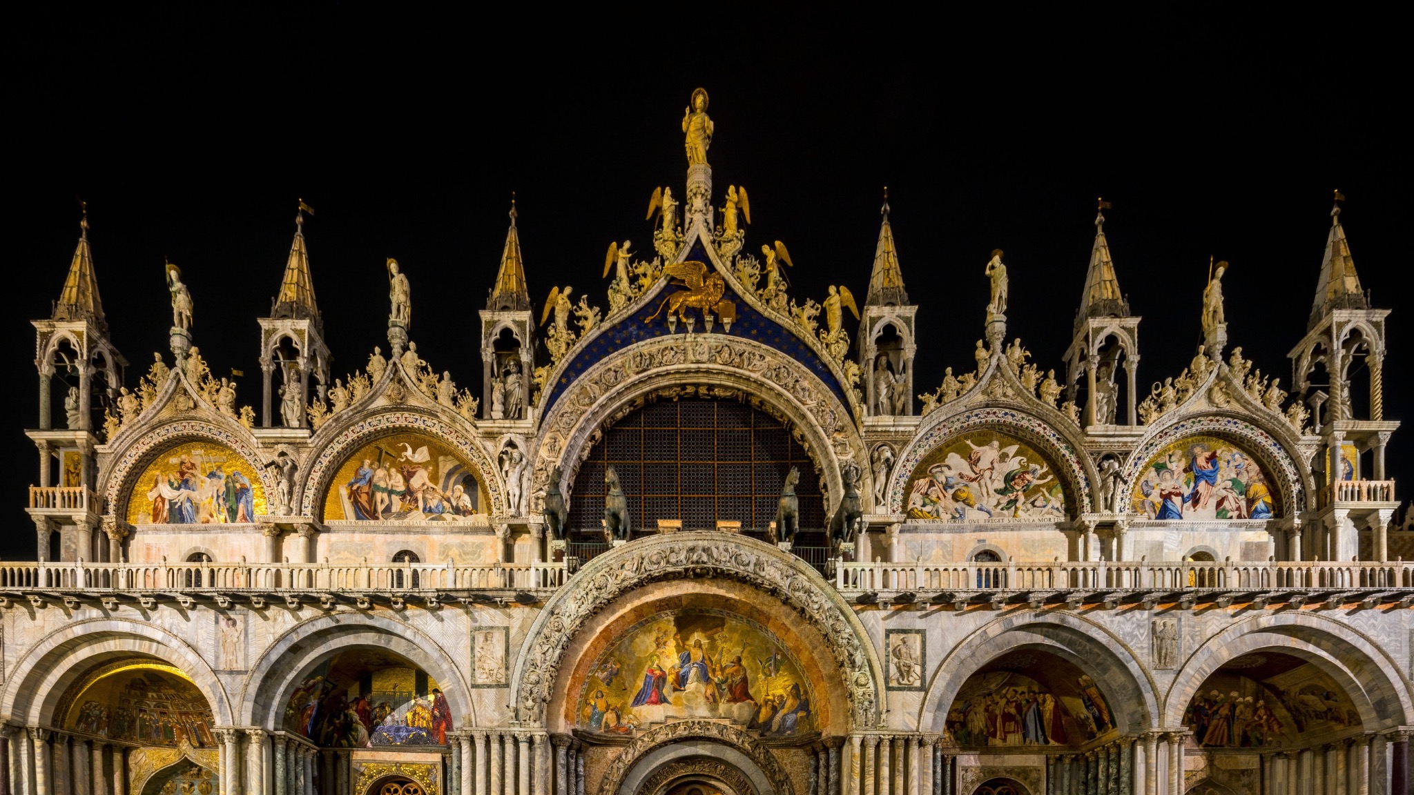 The illuminated façade of St Mark’s Basilica at night in an empty Piazza San Marco